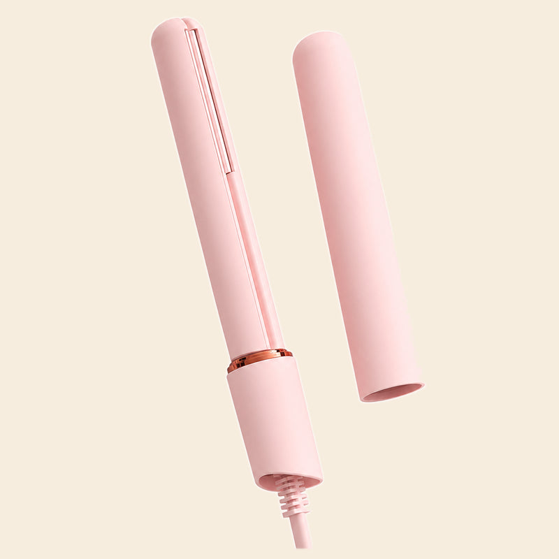 A light pink hair straightener shown with its matching pink cap removed and placed beside it on a solid pale beige background.
